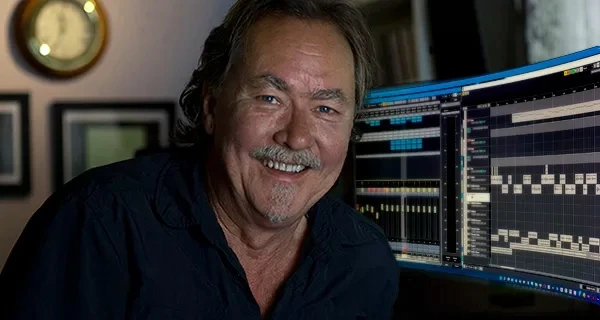 Jeff Watkinson at the desk in the YES AUDIO control room, smiling, multitrack session on the monitors behind him